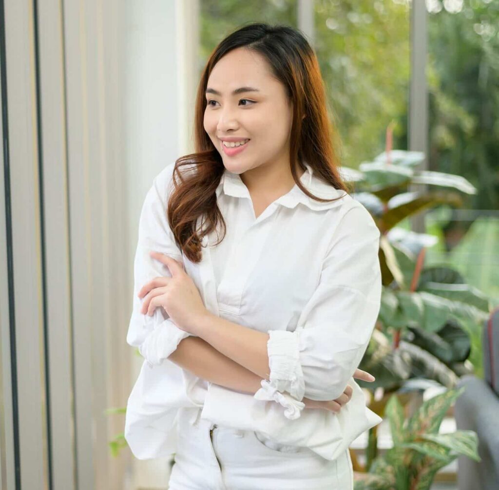 A confident asian woman wearing white polo at home