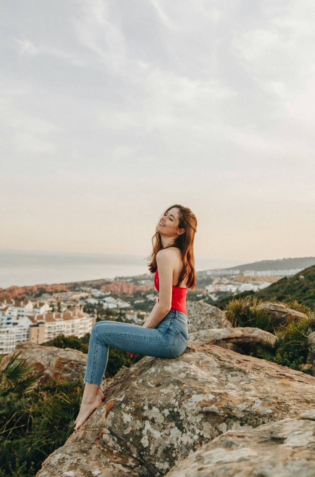 A woman sitting on rock during daytime