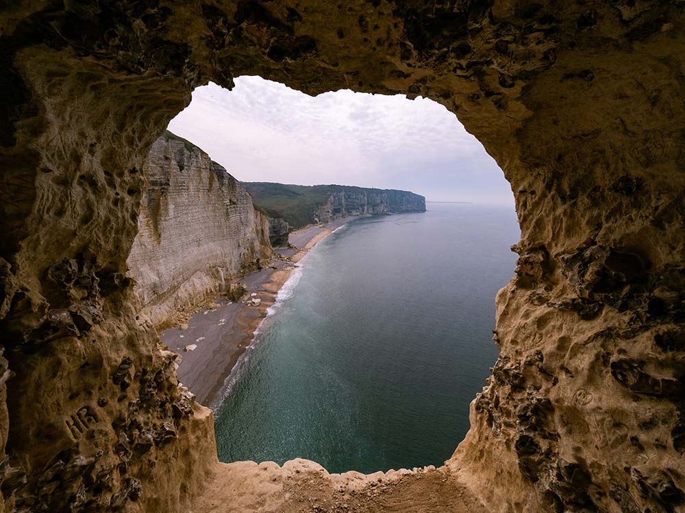 Coastal Cliffs and Beach Viewed Through a Natural Cave Opening